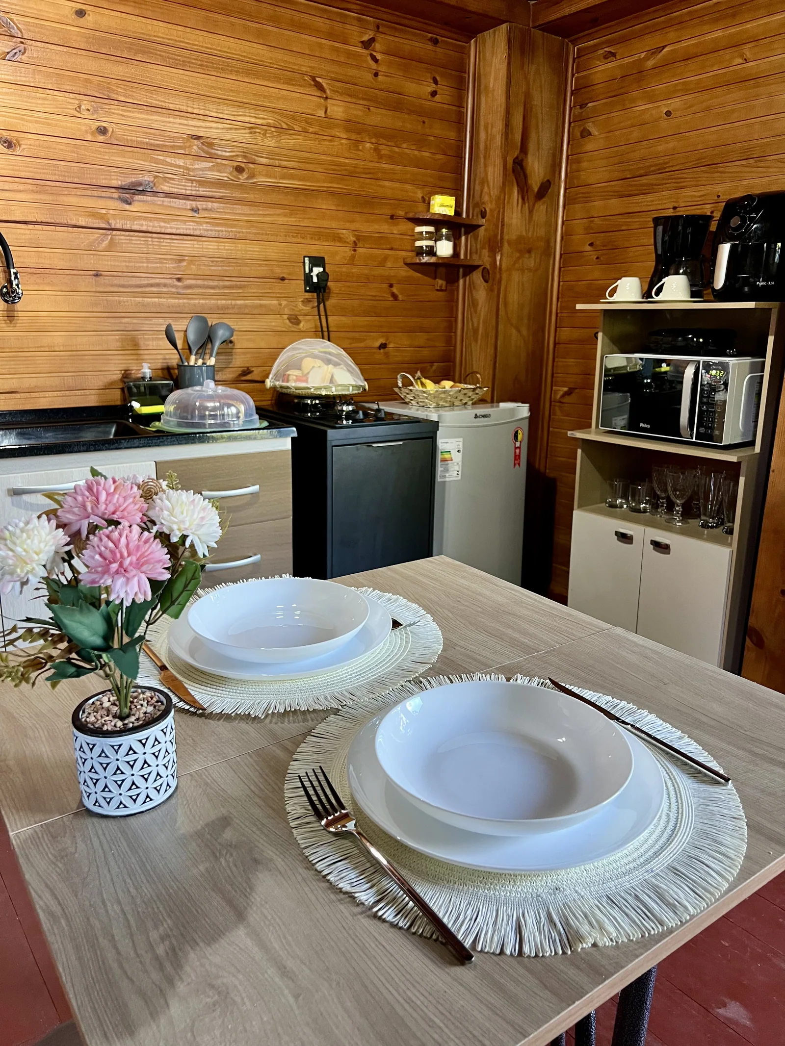 Mesa posta e cozinha de um dos Chalés do Vale
