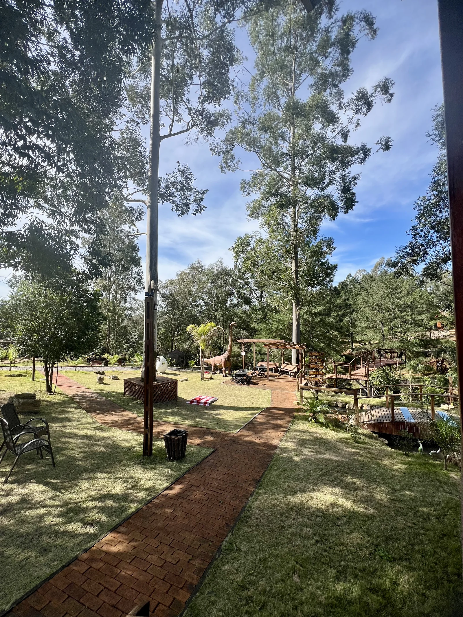 Vista do parque entre árvores, caminhos e dinossauros